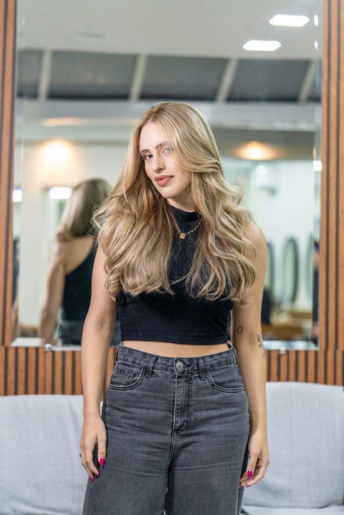 Woman with ash blonde balayage hair standing in a modern salon