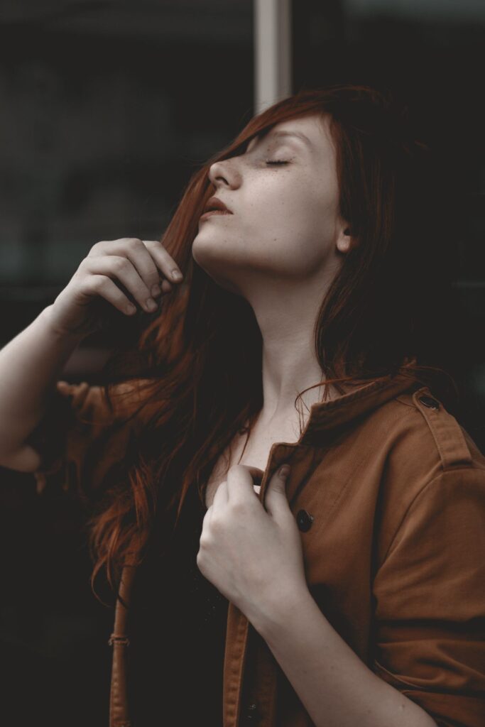 Woman with auburn hair in a contemplative pose