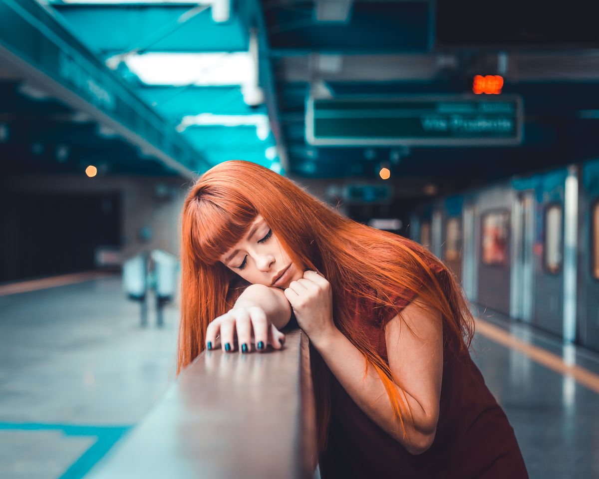The Radiant Appeal of Auburn Hair Color for Women 2 Woman with auburn hair leaning on a railing