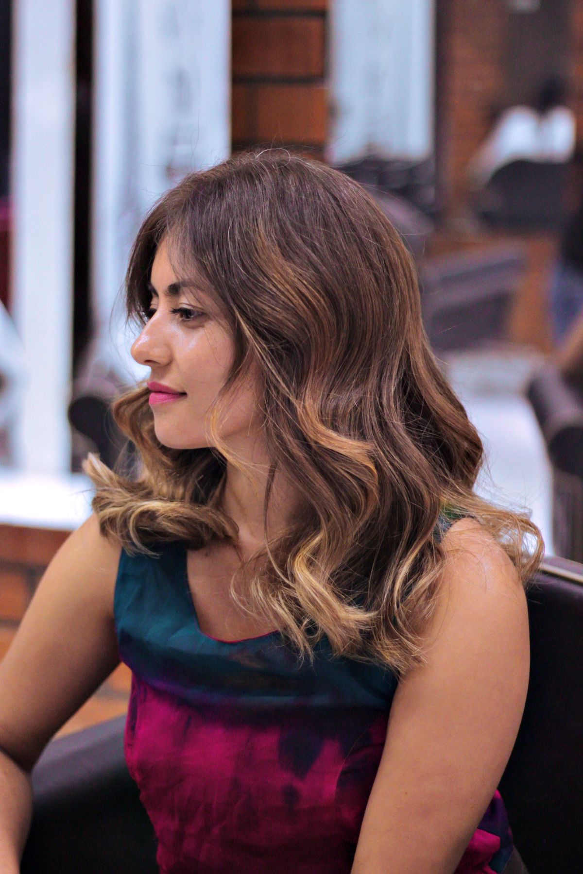 Woman with elegantly styled caramel brown hair in a salon