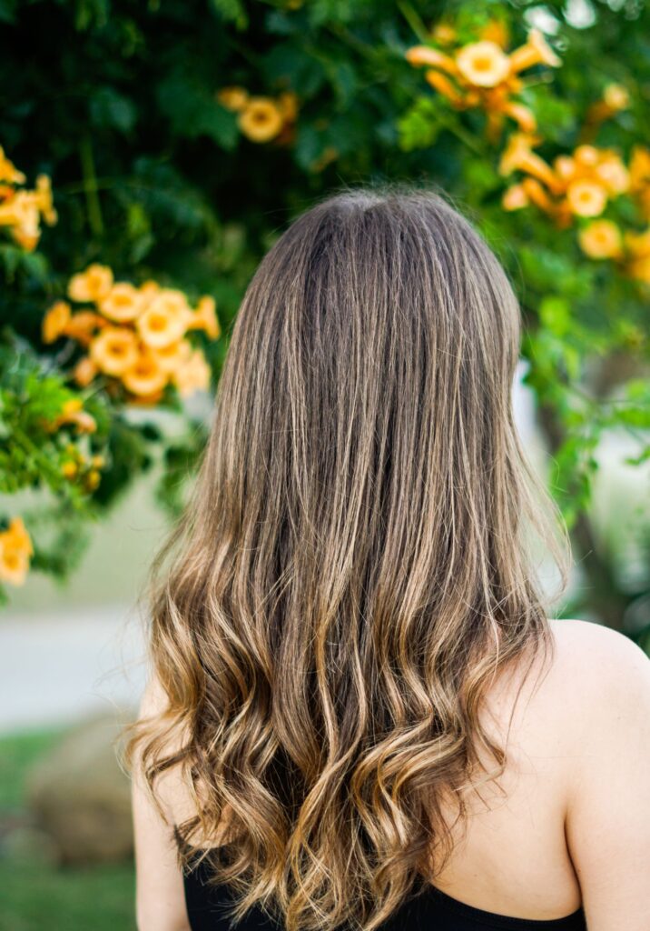 Woman with long chocolate brown balayage hair standing outdoors