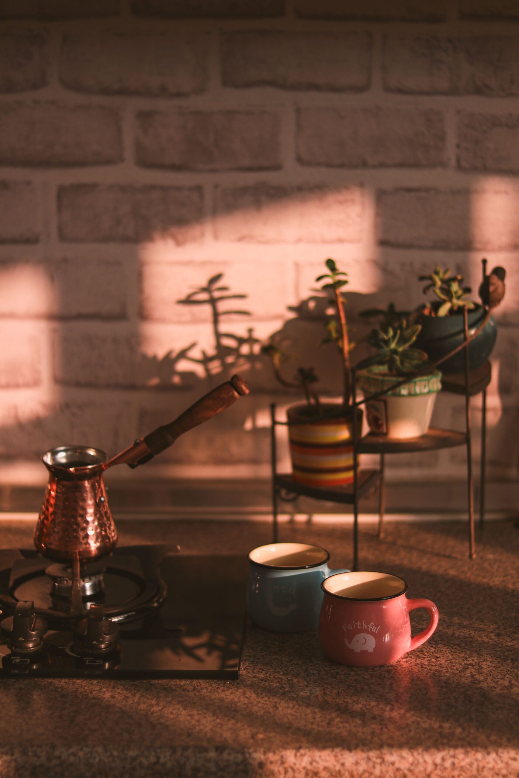 Home Coffee Bar Ideas That Feel Like a Real Café Corner 5 Cozy coffee setup with small potted succulents against a brick wall
