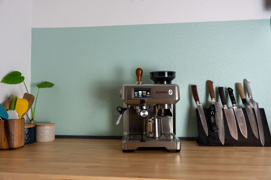 Coffee station with espresso machine, canisters, and warm lighting under cabinet