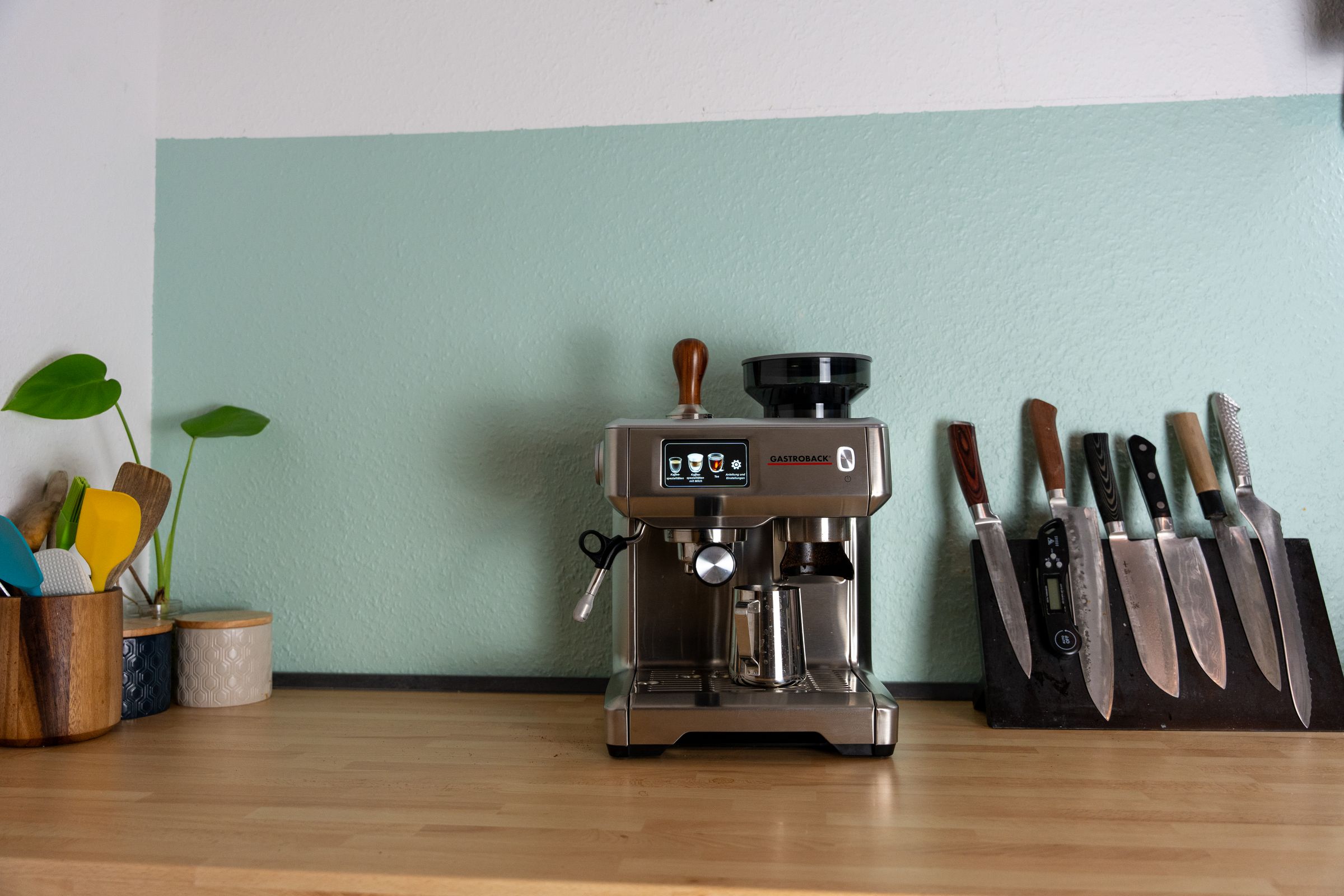 Coffee station with espresso machine, canisters, and warm lighting under cabinet