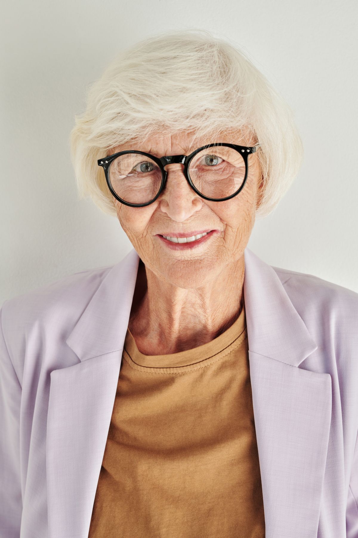 Elegant senior woman smiling confidently in a stylish blazer