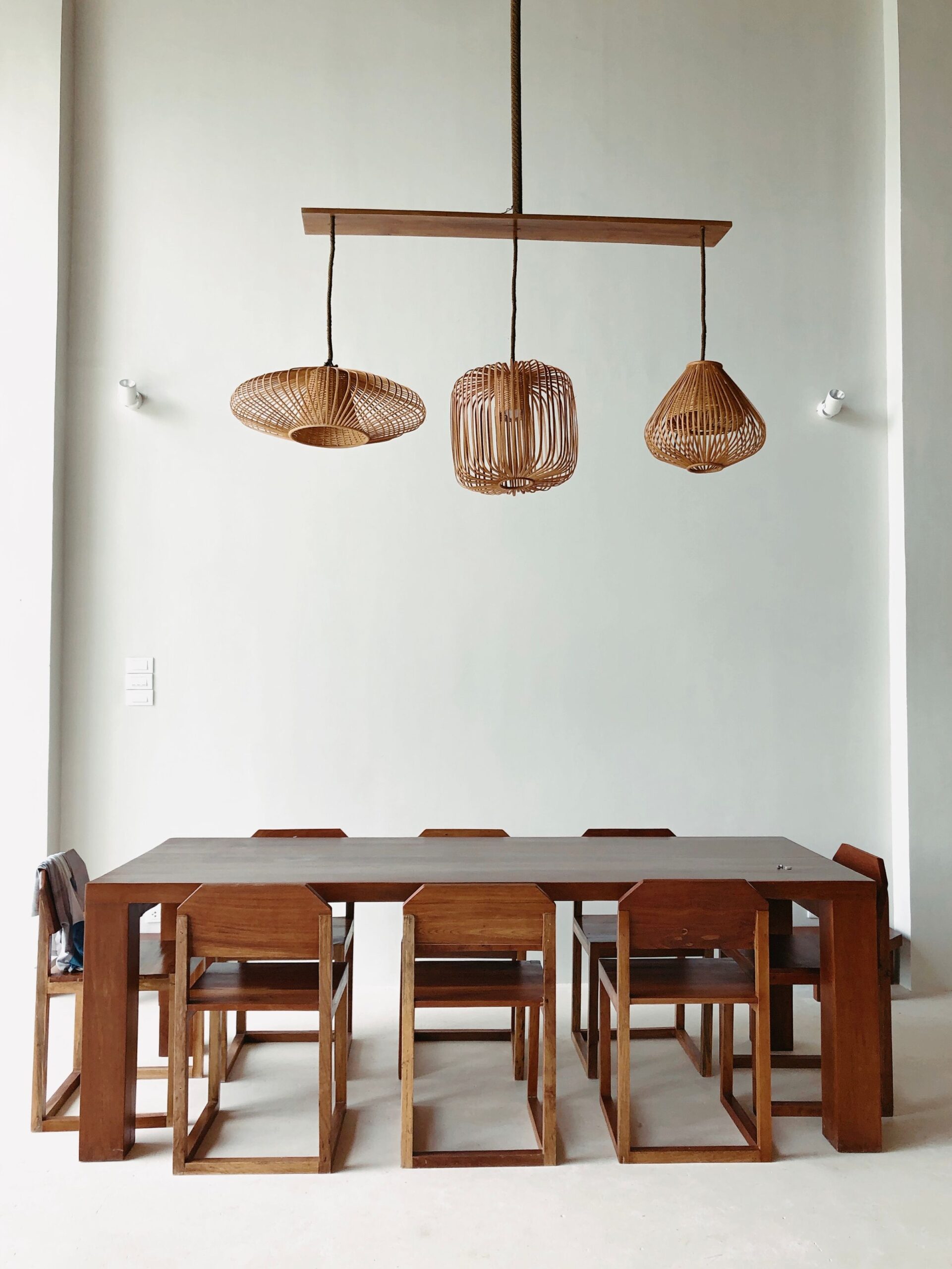Dining Room Decor Ideas That Make Every Meal Feel Special 3 Three woven pendant lights hanging over a wood dining table
