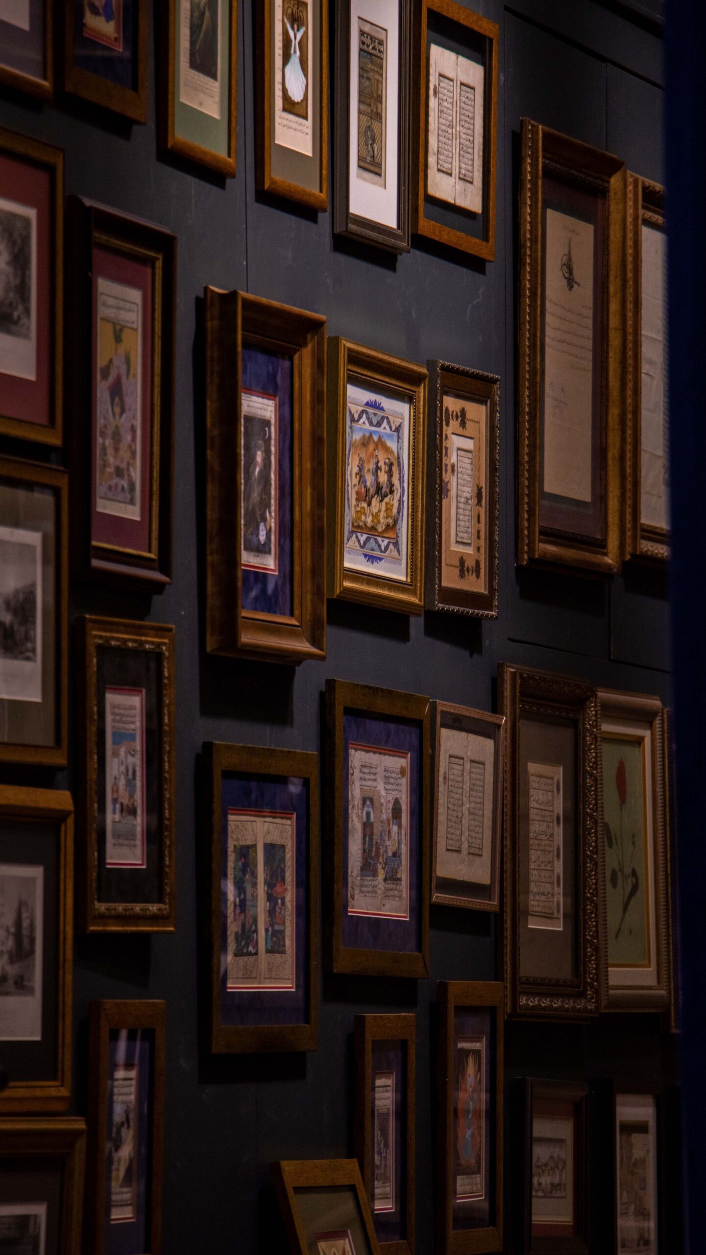 Small wooden picture frames hanging on a wall in an arrangement