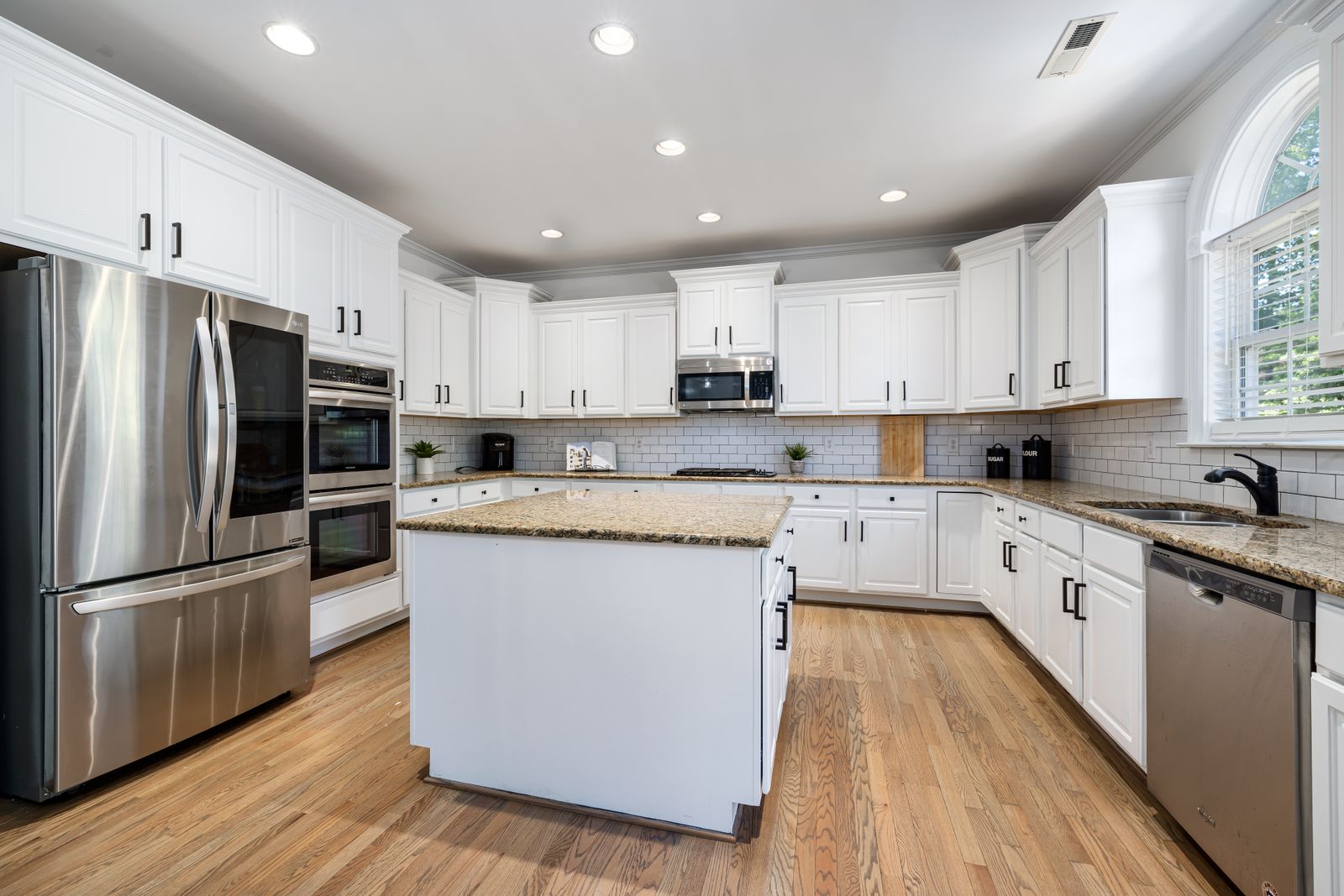 Black cabinet pull handles installed on white cabinets
