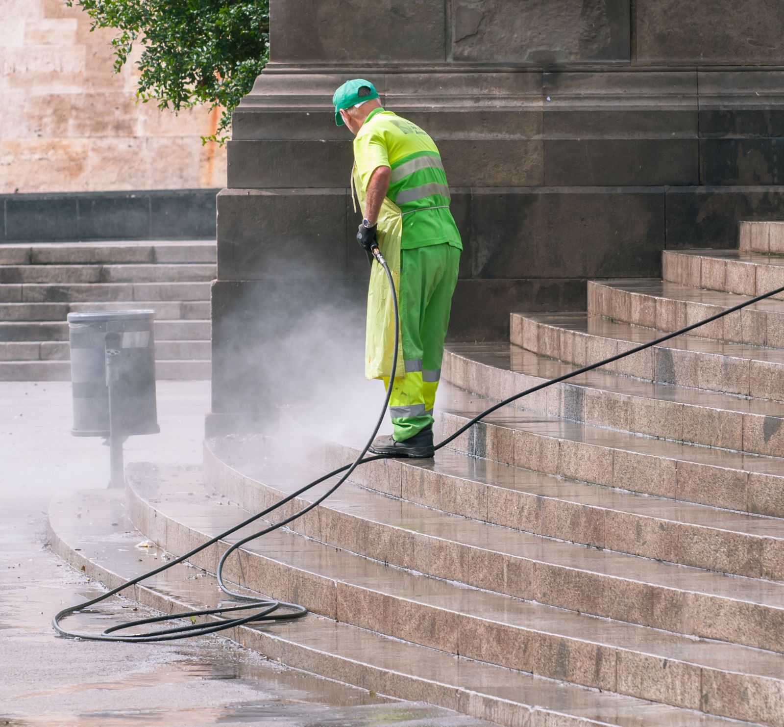 Person power washing outdoor stone steps