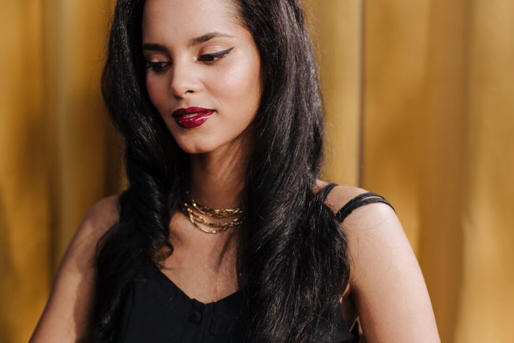 Woman with long jet black hair against a yellow background