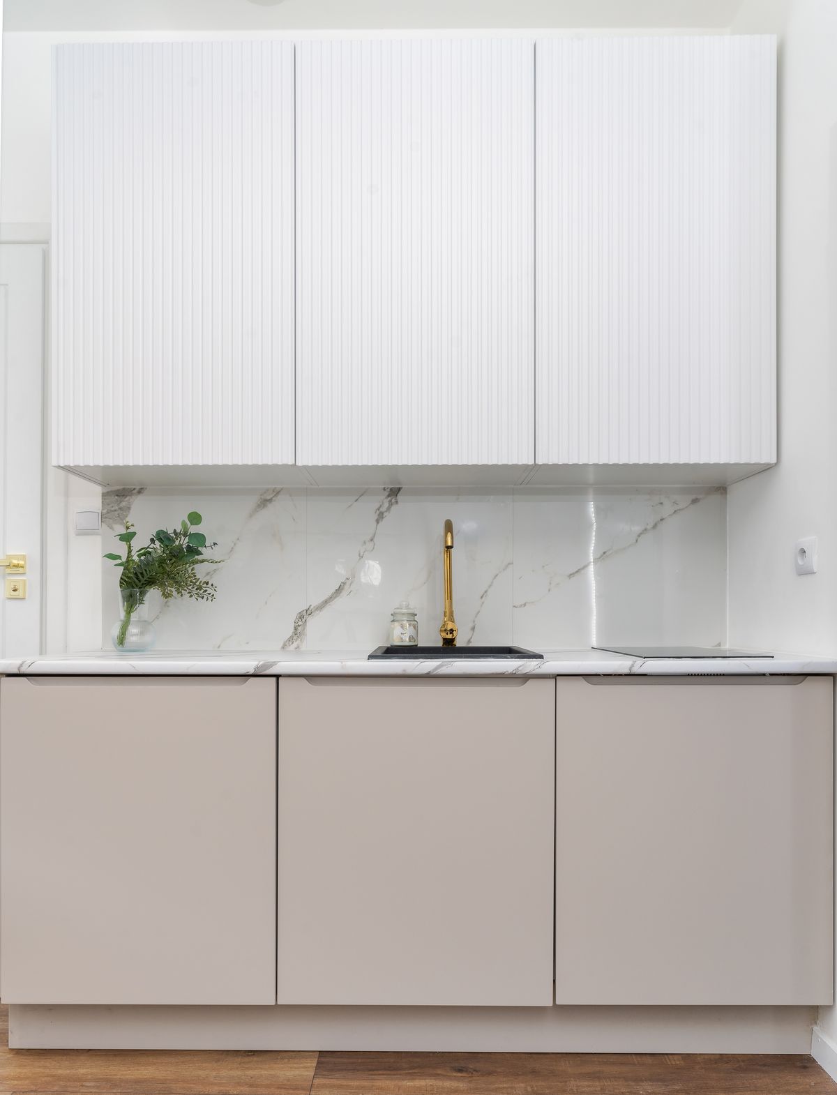 Luxurious minimalist kitchen with marble backsplash and golden faucet
