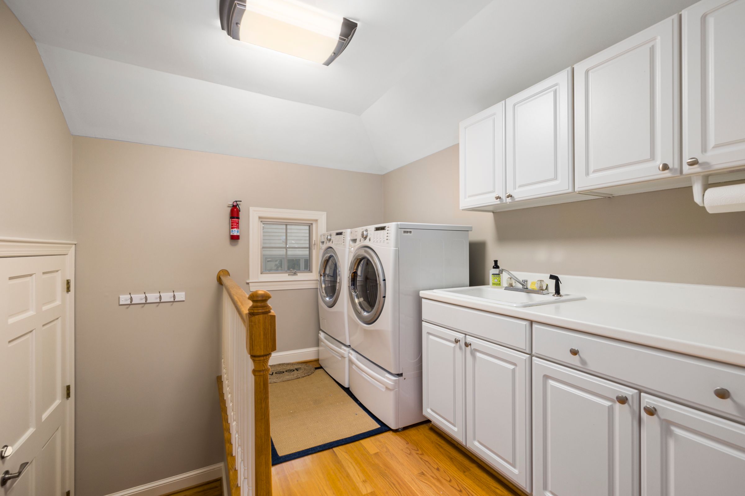 Laundry Room Organization Ideas That Actually Make Sense 3 Laundry room with long white counter, cabinets, and sink