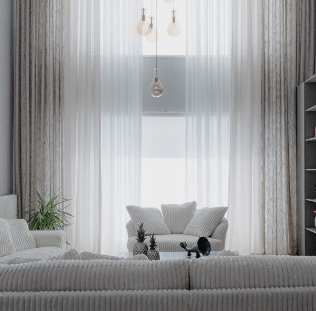 Minimalist living room with soft white sofas and large curtains