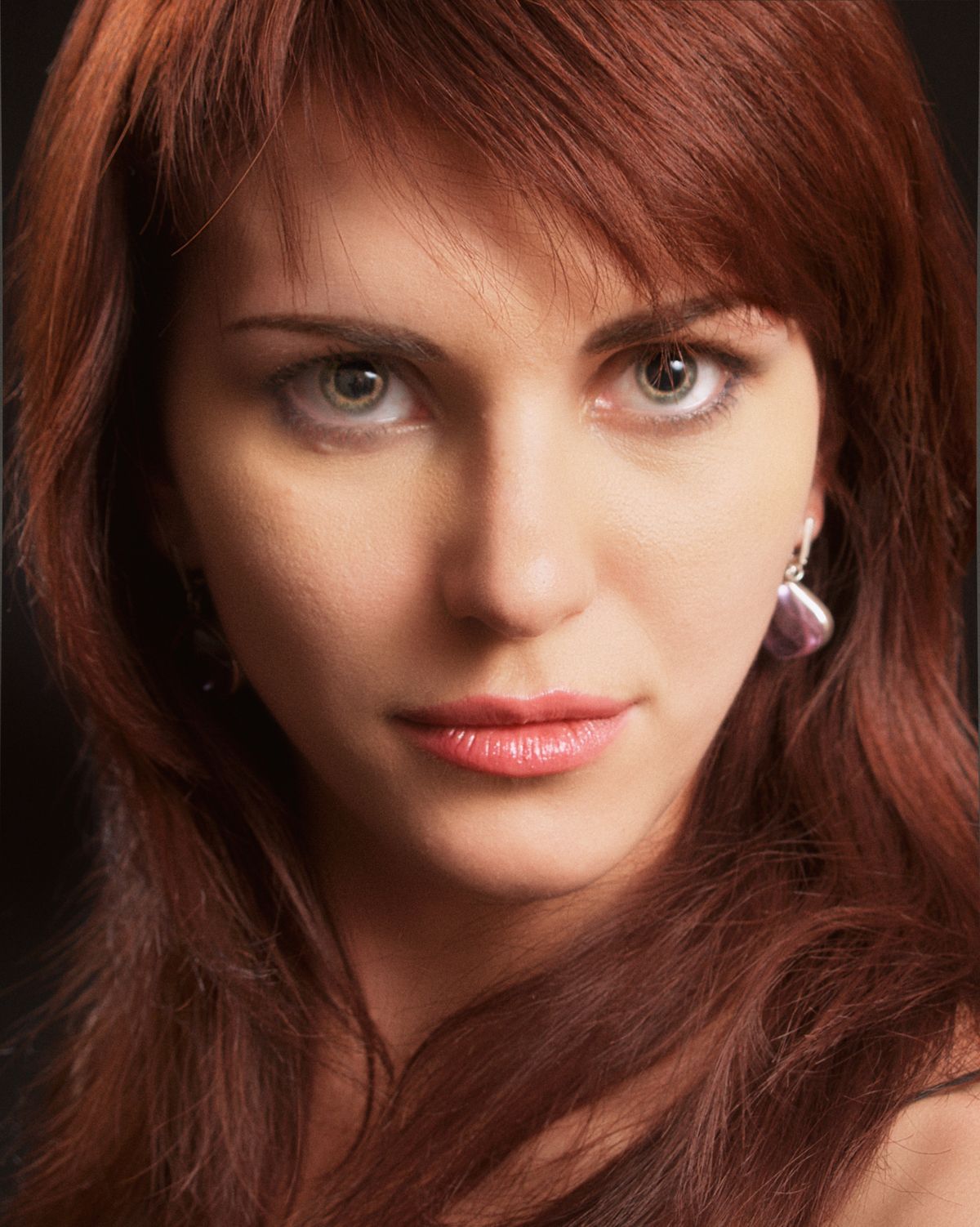 Woman with mahogany hair color in a studio setting