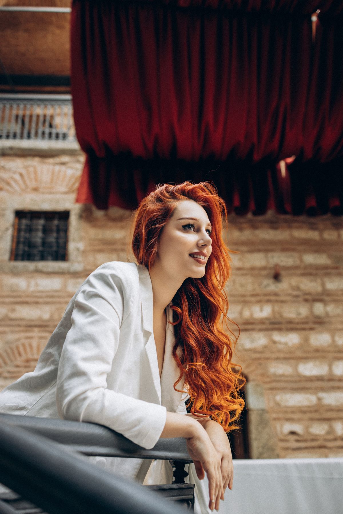The Glamorous Depth of Mahogany Hair Color for Women 2 Woman with mahogany red hair in a white blazer