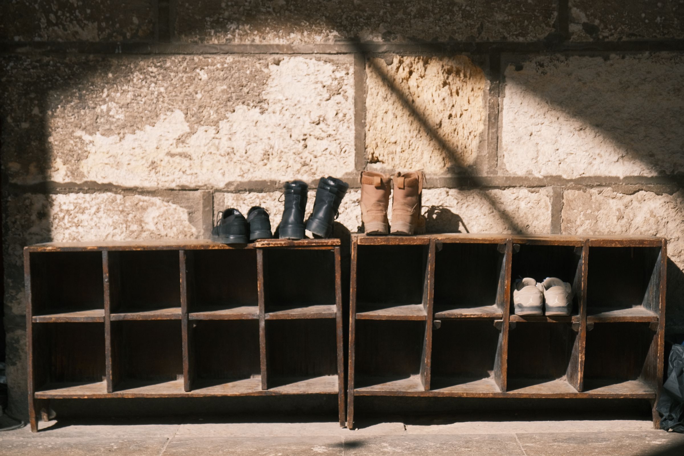 7 Mudroom Organization Ideas That Actually Make Sense 5 Wooden shoe rack holding several pairs of footwear