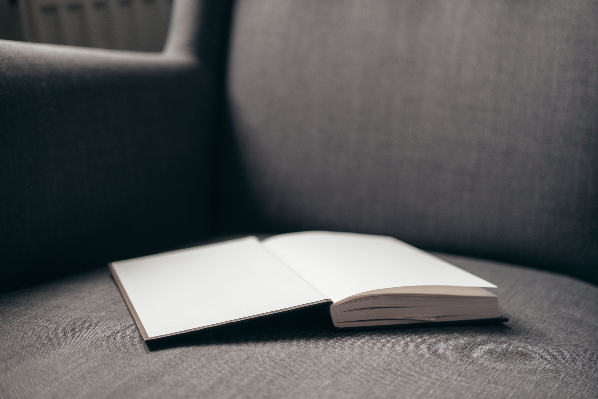7 Cozy Reading Nook Ideas That Make You Want to Sit Down and Stay 6 Open book resting on a cozy upholstered armchair
