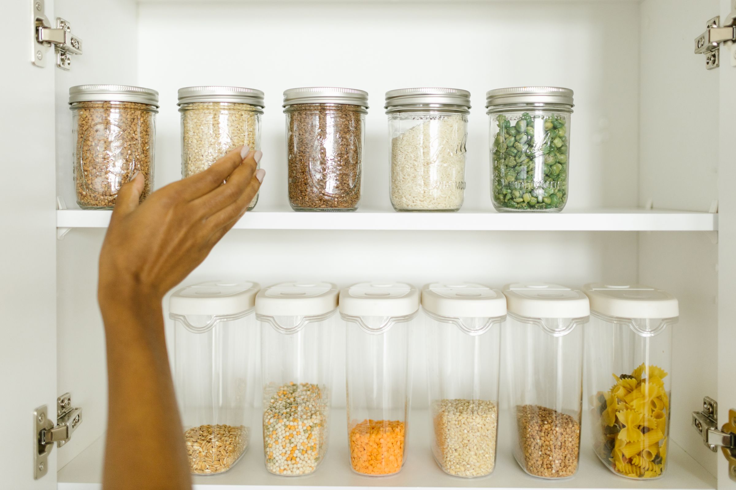 7 Pantry Organization Ideas That Actually Stay Organized 3 Dry goods organized by category in glass containers on a shelf