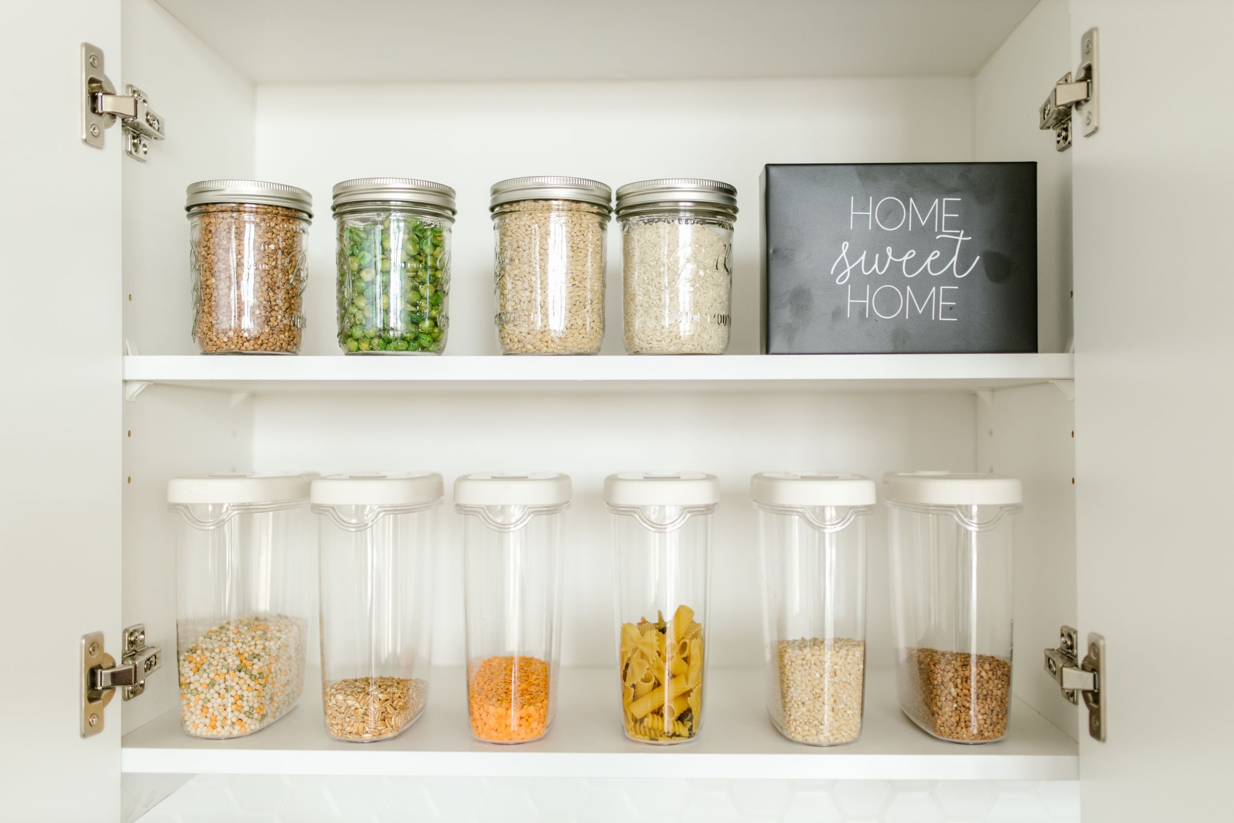7 Pantry Organization Ideas That Actually Stay Organized 2 Clear glass jars organized on a white wooden pantry shelf