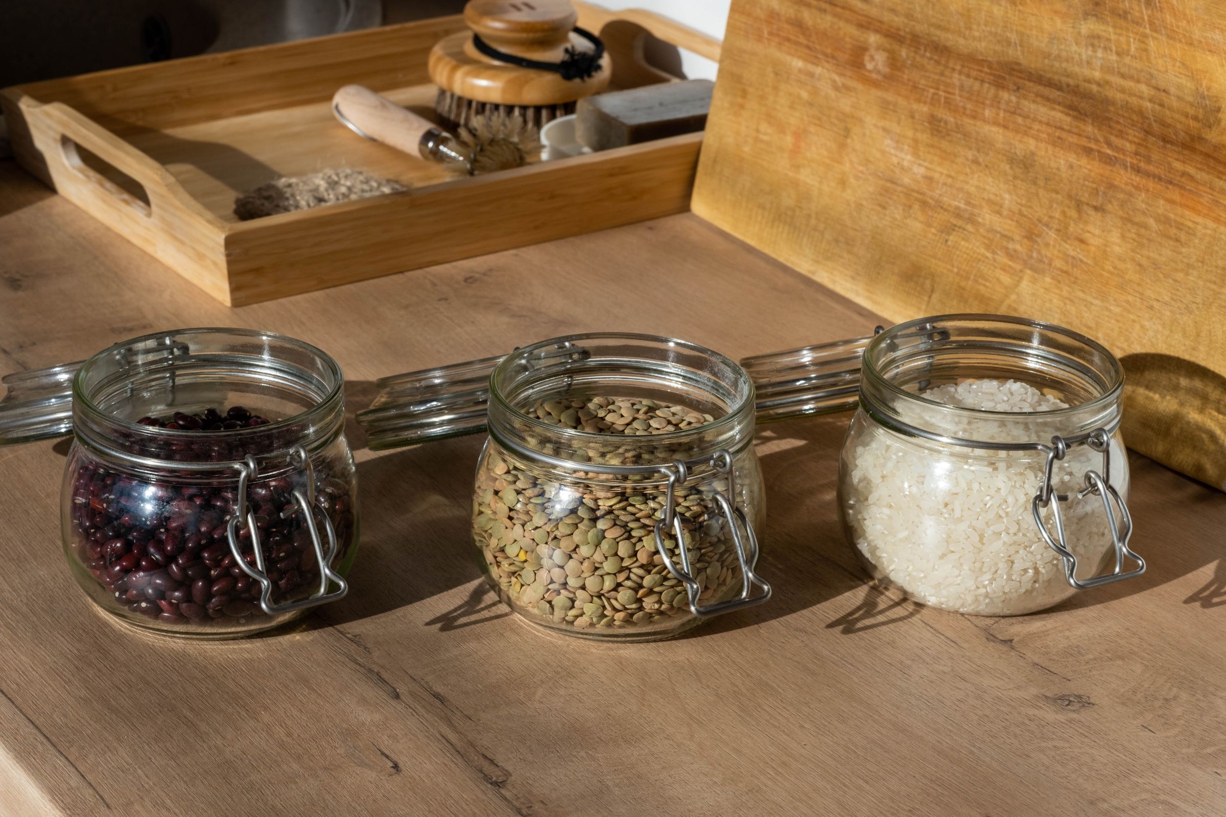 7 Pantry Organization Ideas That Actually Stay Organized 6 Clear glass jars with beans seeds and rice arranged on a table