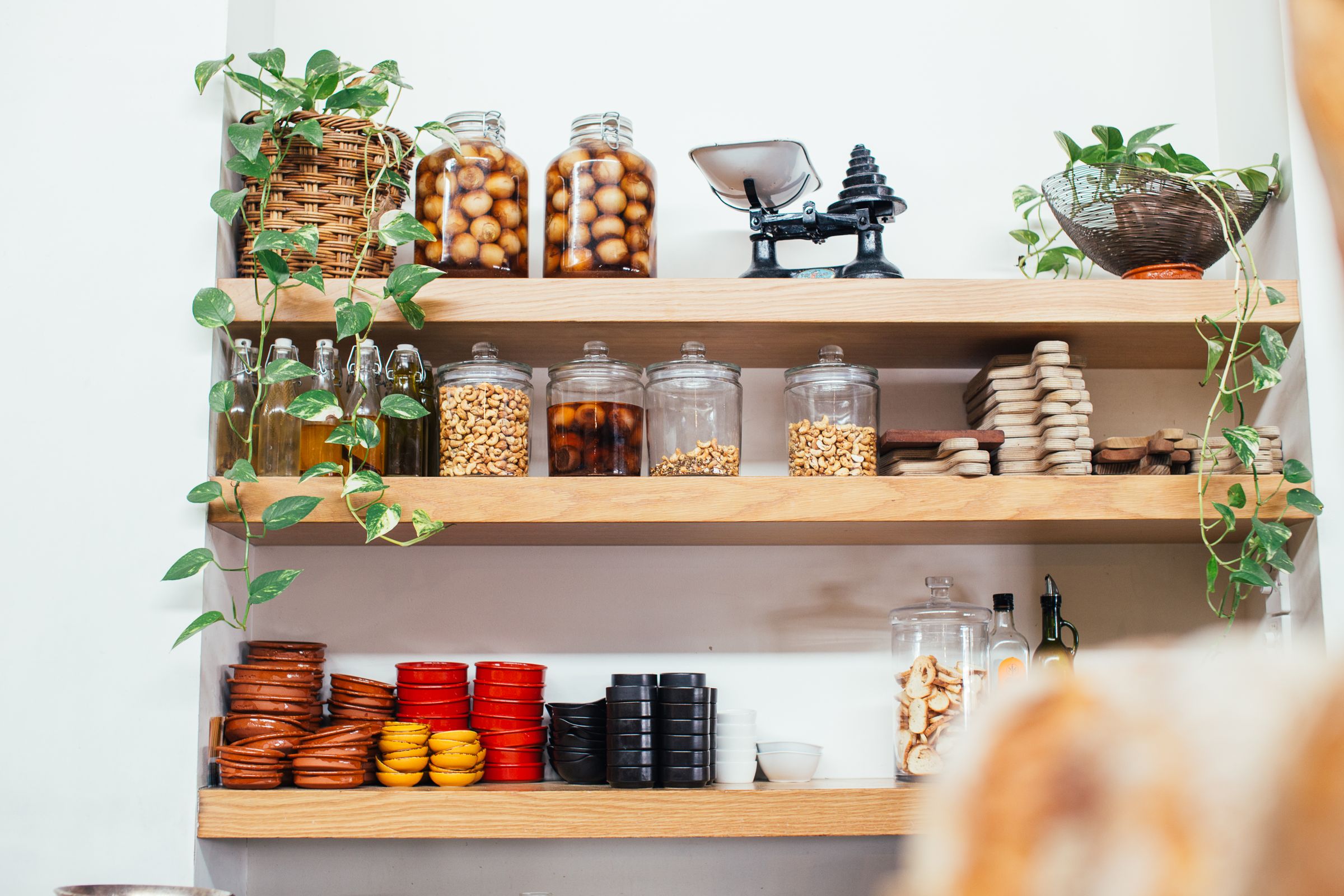 7 Pantry Organization Ideas That Actually Stay Organized 4 Wooden pantry shelves with glass jars filled with everyday ingredients