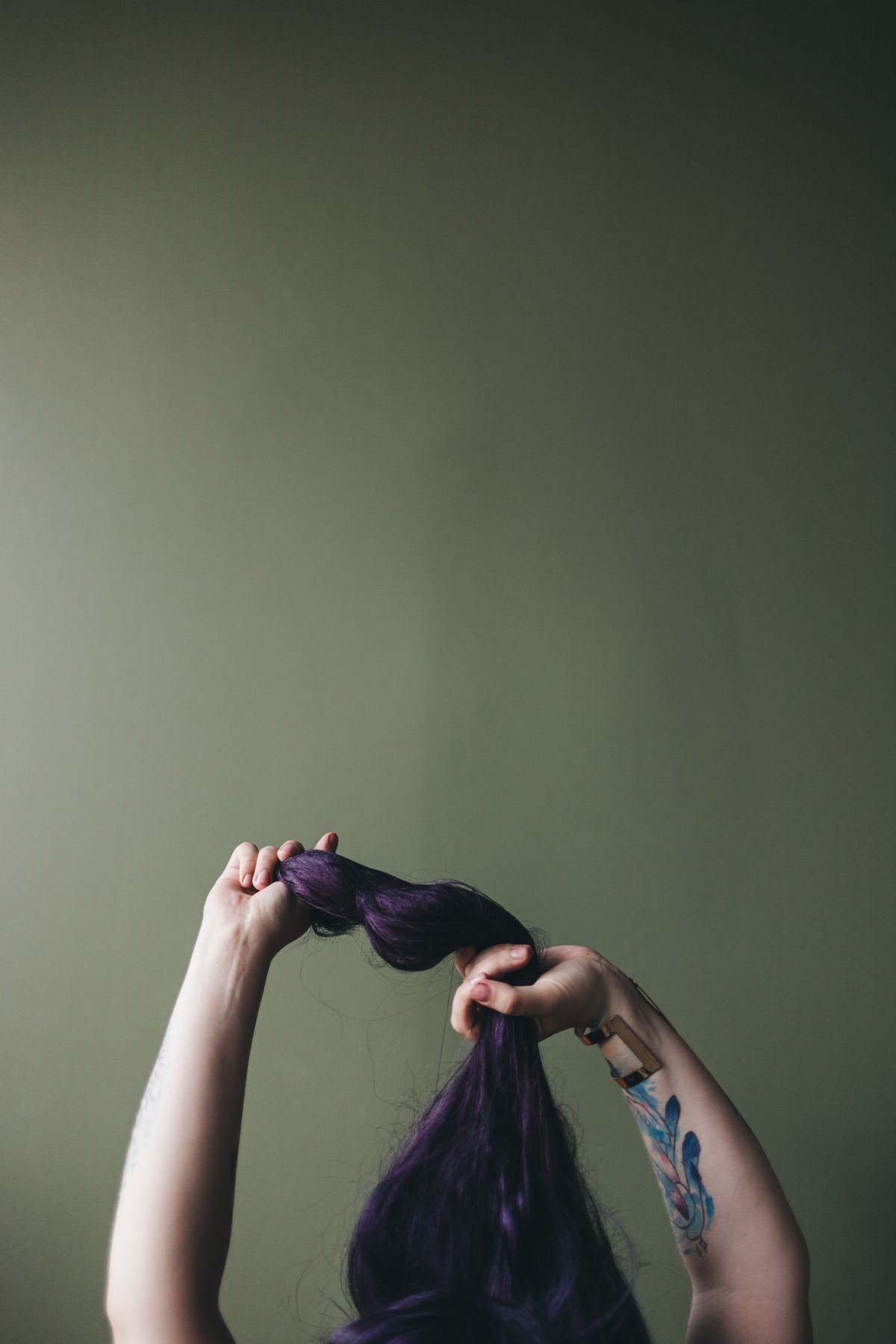 The Bold Elegance of Plum Purple Hair Color for Women 2 Hands styling long purple hair
