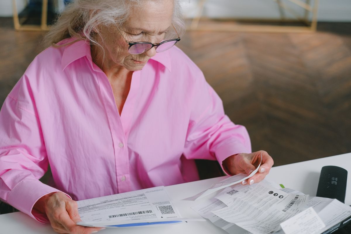 Financial Independence and Empowerment for Older Women 2 Elderly woman reading financial documents at a table