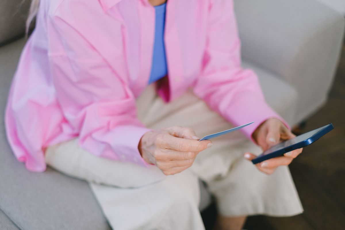 Financial Independence and Empowerment for Older Women 5 Elderly woman holding a credit card and smartphone