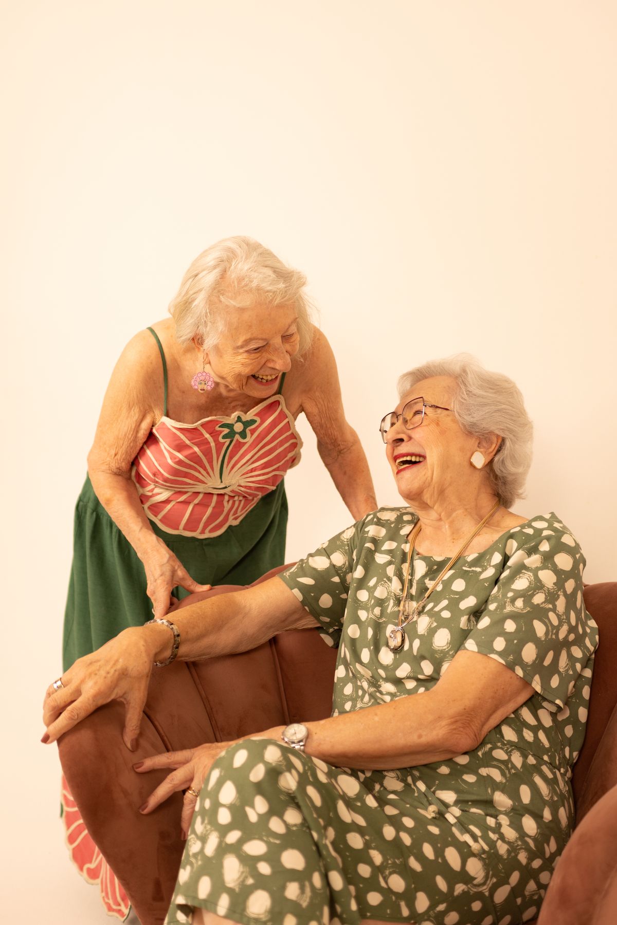 The Beauty, Strength, and Wisdom of Older Women: Embracing Life with Confidence 6 Two senior women laughing together in a cozy indoor setting