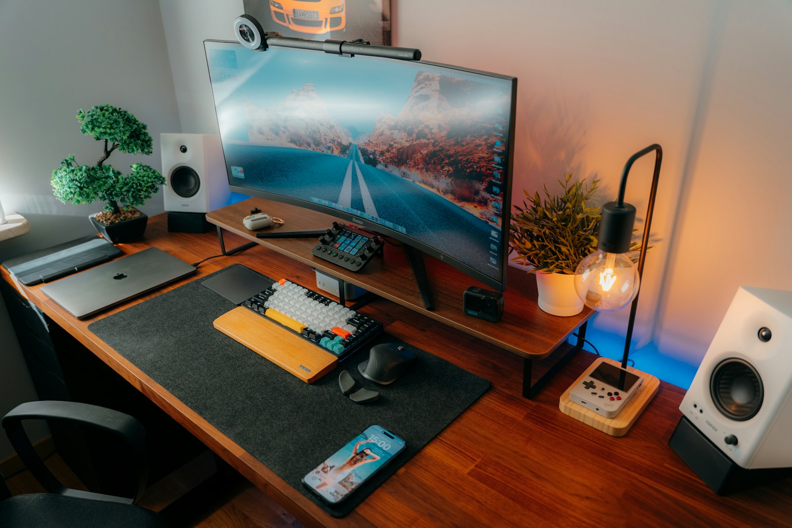Compact home office desk setup with monitor, keyboard, and ambient lighting