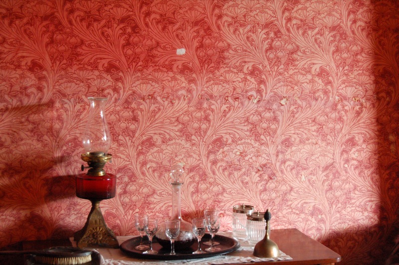 Dining room with bold patterned wallpaper covering the walls