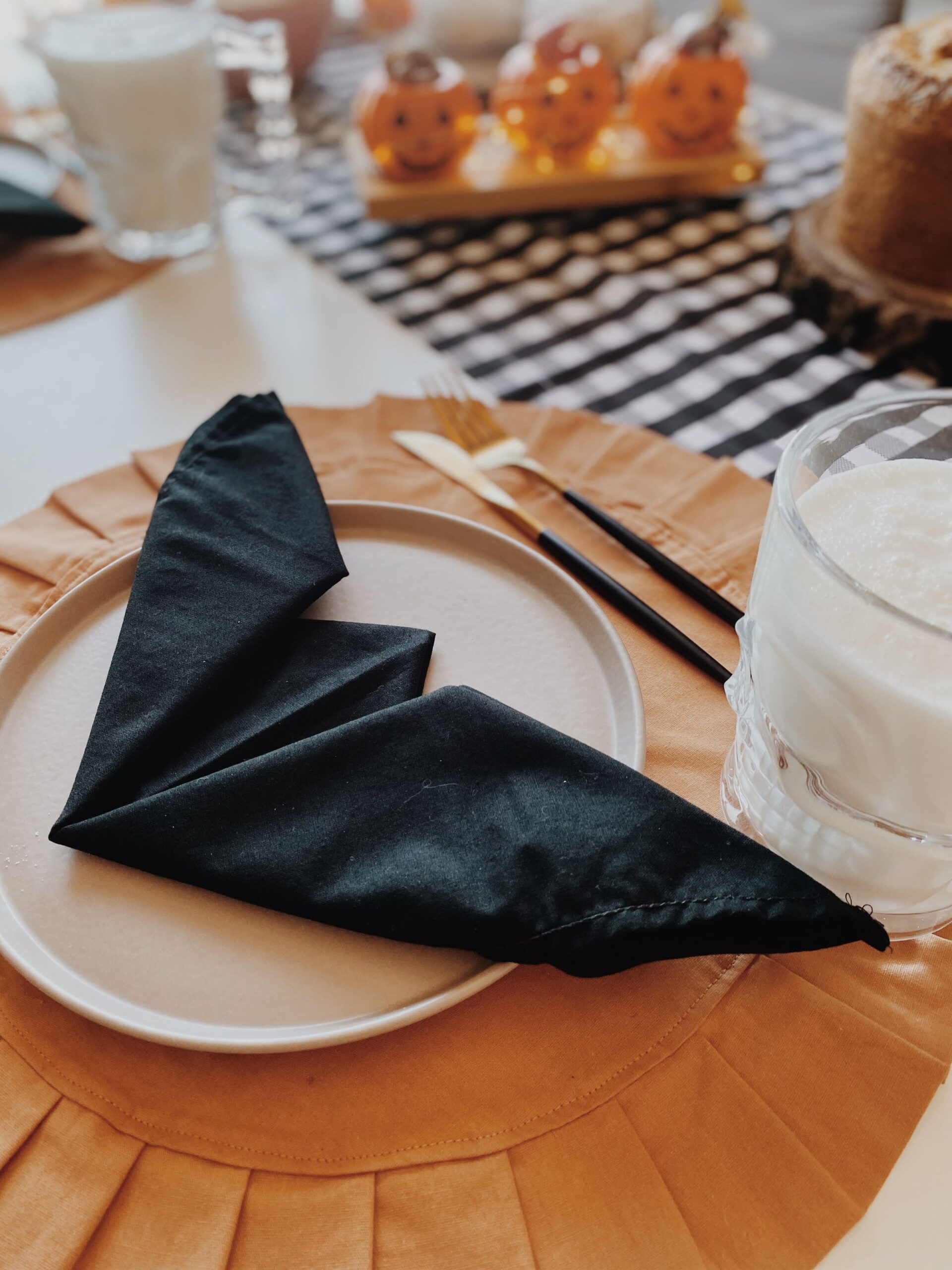 Elegant Halloween Decor Ideas for Every Room in Your Home 3 Elegant Halloween dining table setting with dark place settings and candles, photo by Anna Zanovelli Bacci via Pexels
