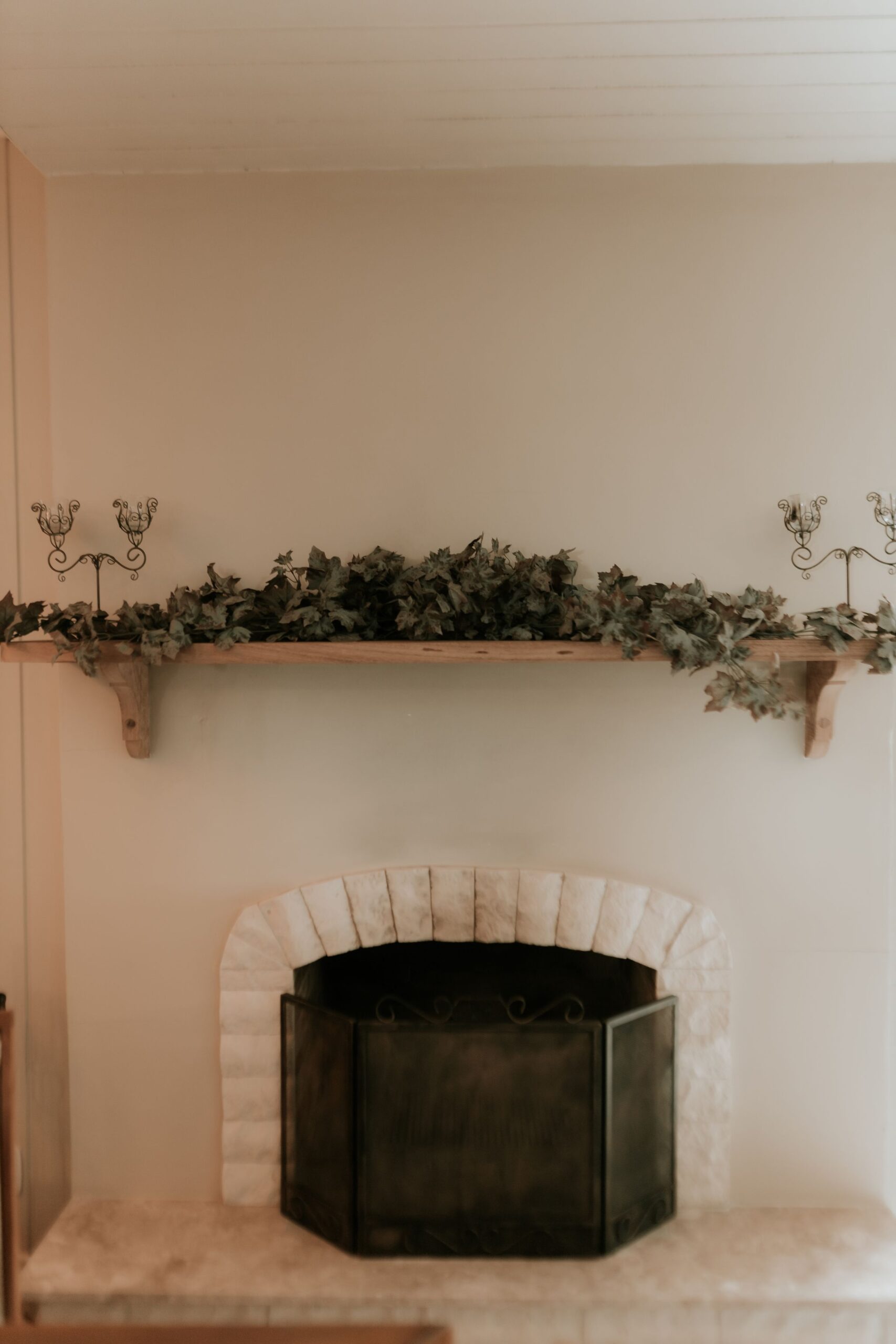 Elegant Halloween Decor Ideas for Every Room in Your Home 2 Elegant fireplace mantel styled with greenery and ornate candleholders, photo by Alexander Mass via Pexels
