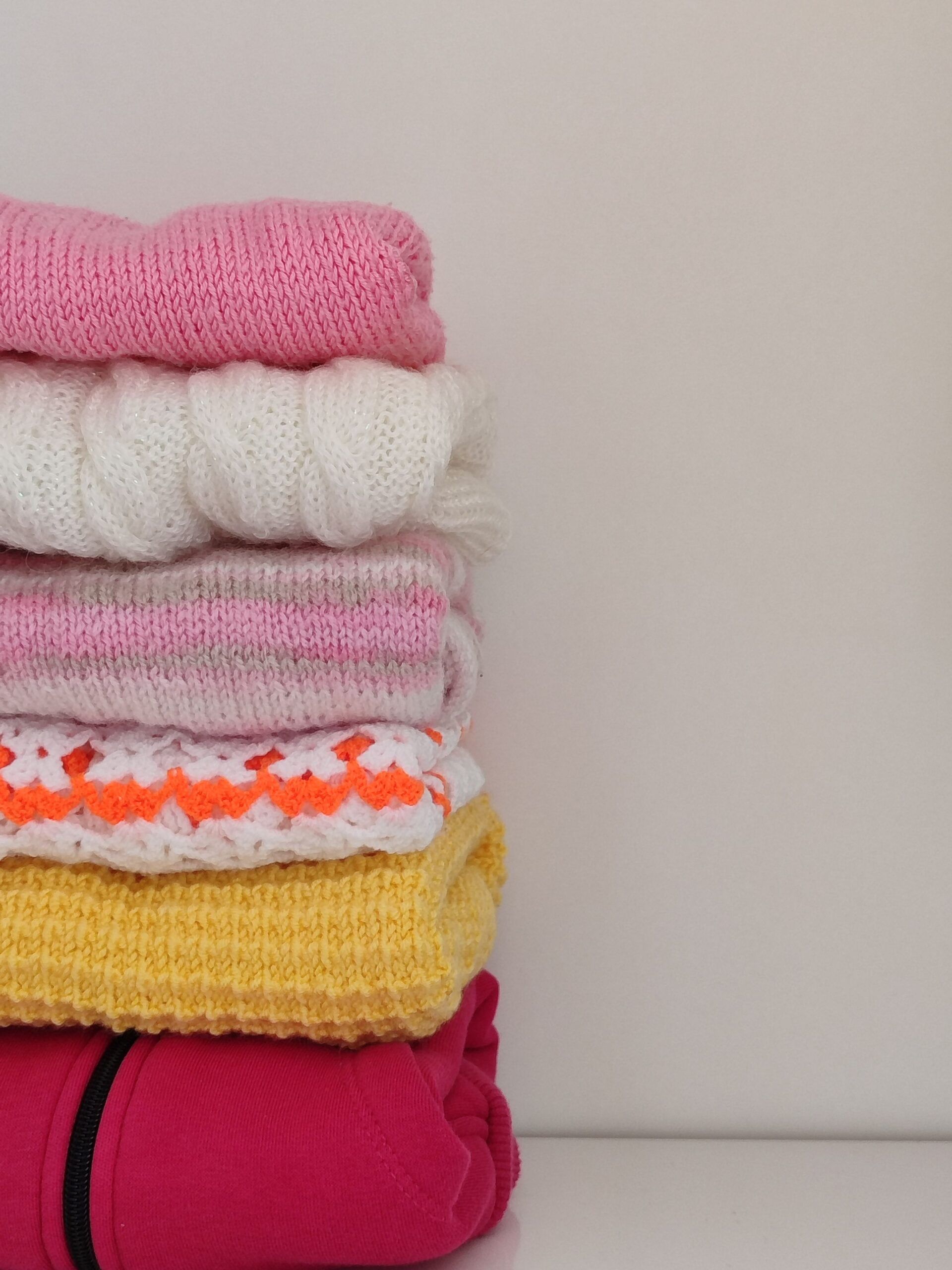Closet Organization Ideas That Actually Make Getting Dressed Easier 3 Neatly stacked folded sweaters organized on a shelf, photo by Nur Tok via Pexels